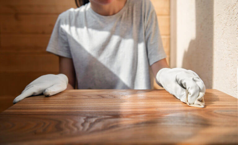 A young girl in work gloves is covering a wooden tabletop with o | Pine and Oak Pine and Oak Furniture Care