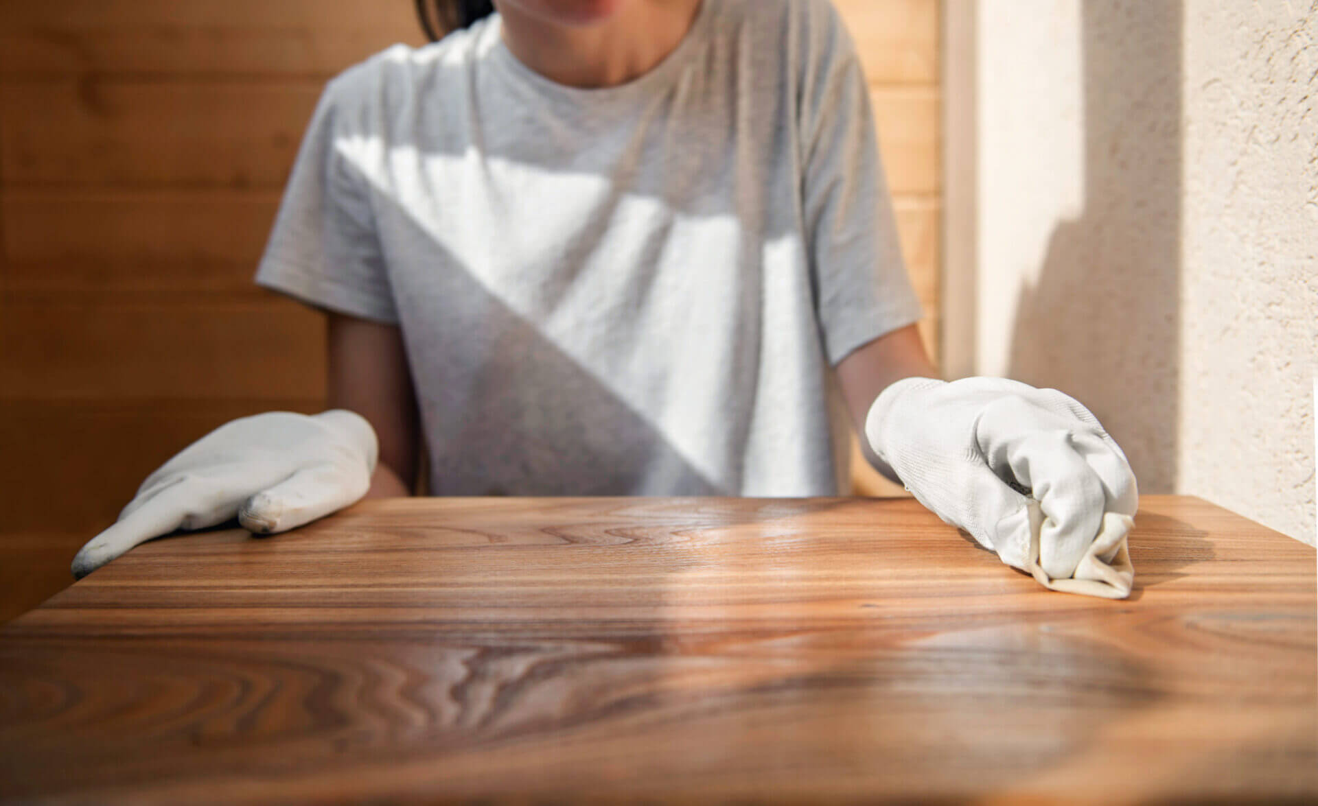 A young girl in work gloves is covering a wooden tabletop with o | Pine and Oak Pine and Oak Furniture Care